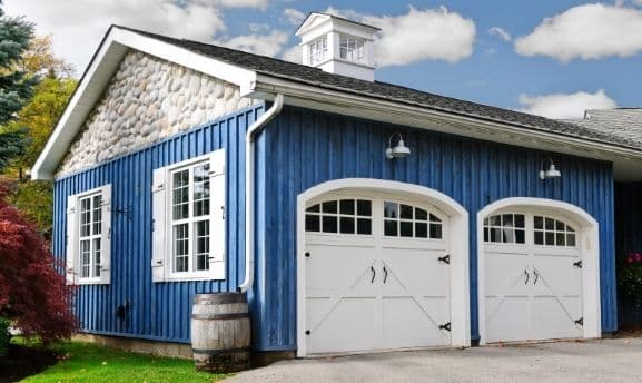 Custom garage build kit featuring blue siding and stone accents