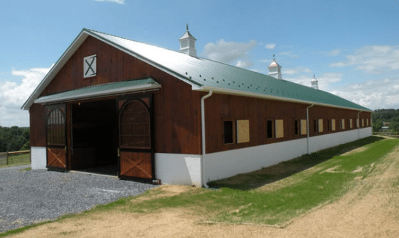 Center aisle horse barn kit with green metal roof