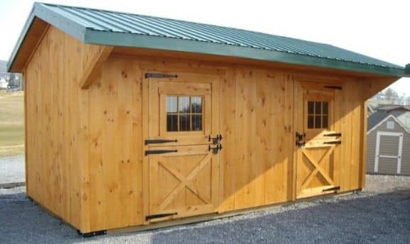 Small horse barn kit styled with green metal roof